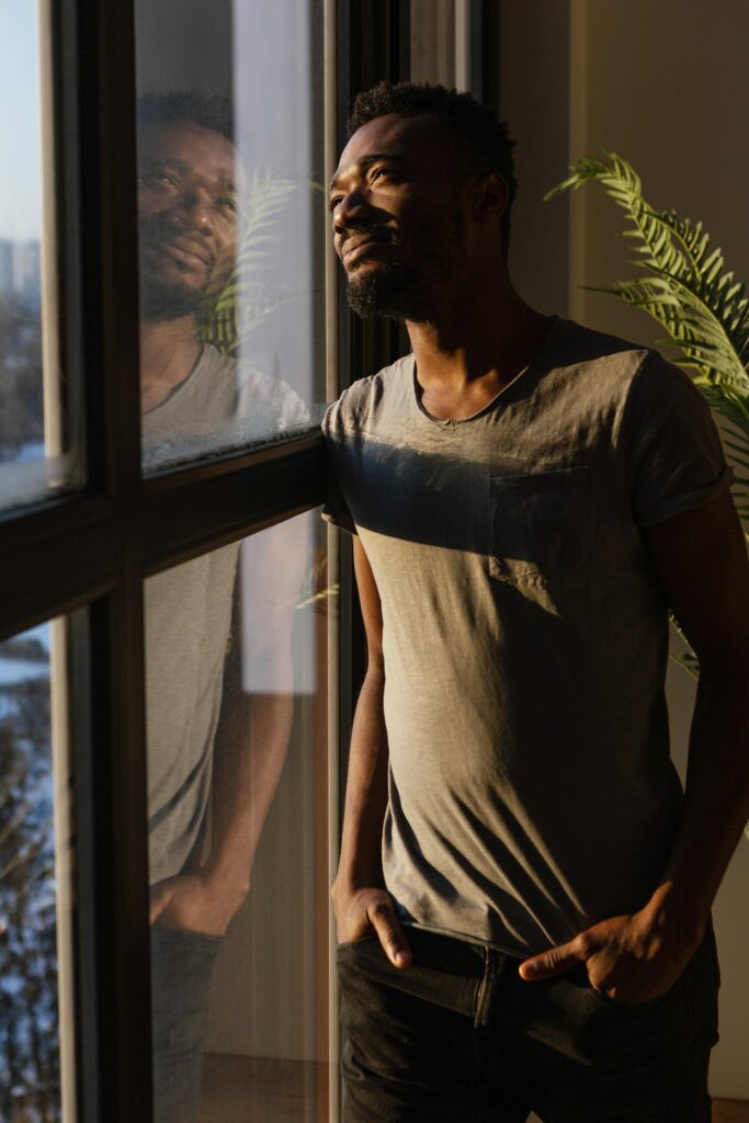 medium-shot-man-looking-out-window